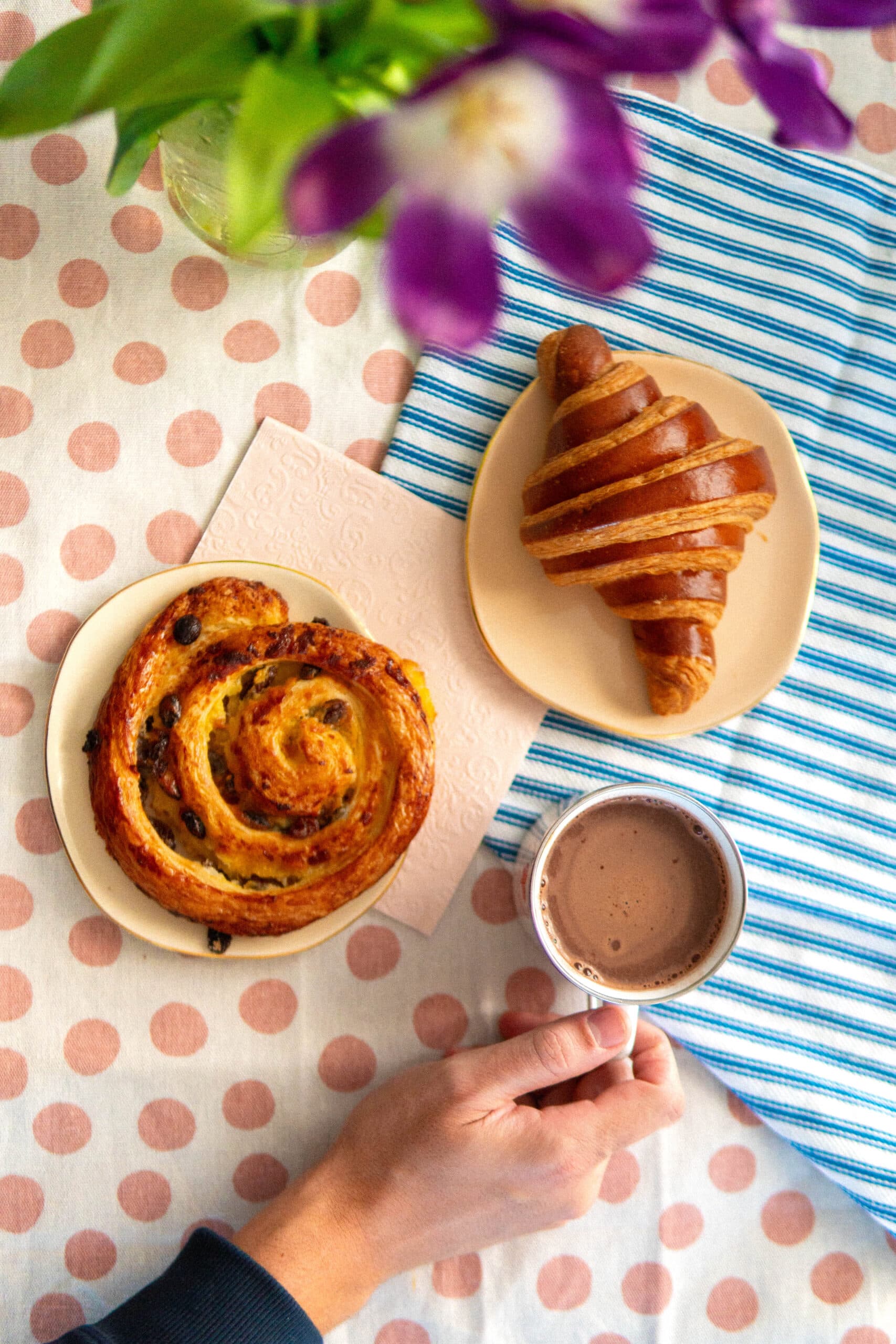 Croissant, pain aux raisins et chocolat chaud sur une table